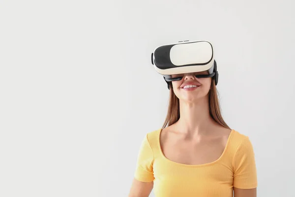 Jovem com óculos de realidade virtual no fundo claro — Fotografia de Stock