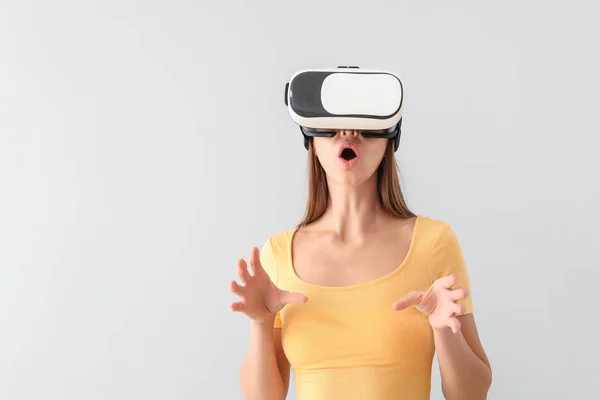 Fiatal nő virtuális valóság szemüveg a fény háttér — Stock Fotó