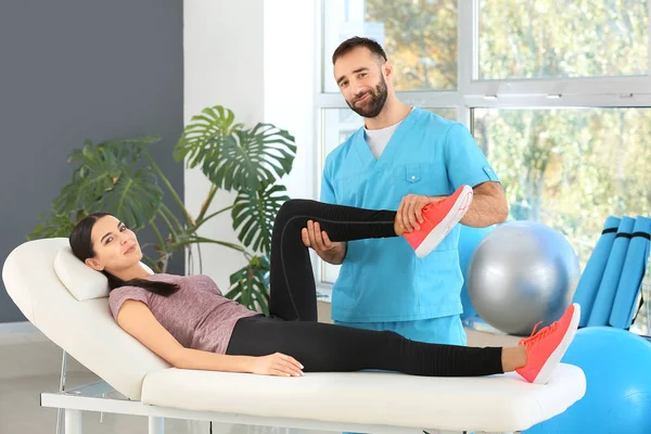 Physiotherapist working with female patient in rehabilitation center — Stock Photo, Image