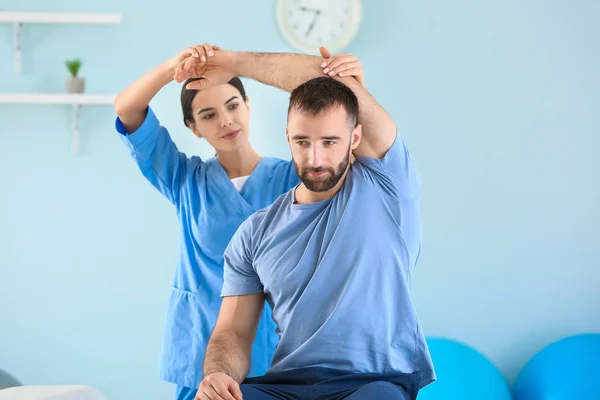 Physiotherapist working with male patient in rehabilitation center — Stock Photo, Image