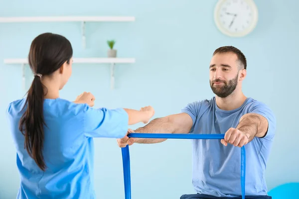 Fisioterapeuta trabajando con paciente masculino en centro de rehabilitación —  Fotos de Stock