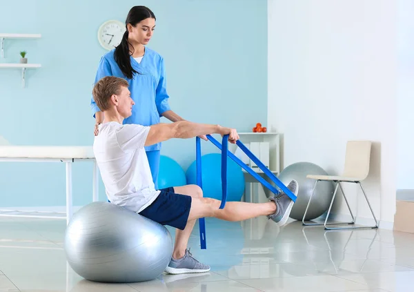 Fisioterapeuta trabajando con paciente masculino en centro de rehabilitación —  Fotos de Stock
