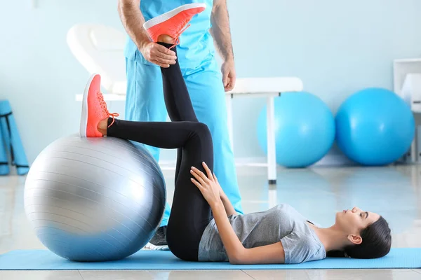 Fisioterapeuta trabajando con paciente femenina en centro de rehabilitación — Foto de Stock