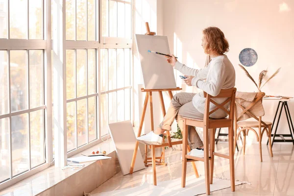 Young male artist painting in studio — Stock Photo, Image
