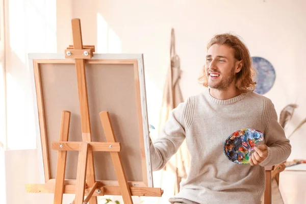 Jonge mannelijke kunstenaar schilderen in atelier — Stockfoto