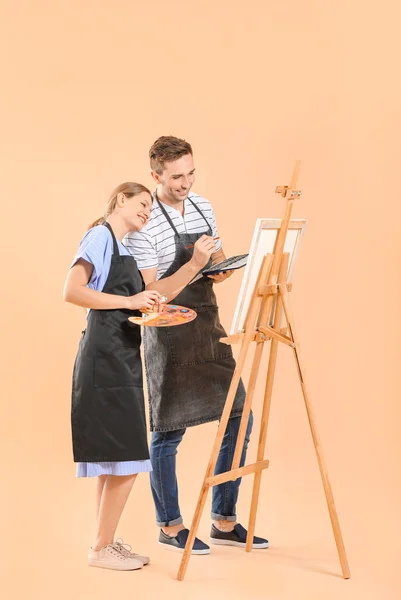 Couple of young artists on color background — Stock Photo, Image