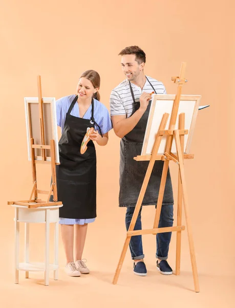 Couple of young artists on color background — Stock Photo, Image