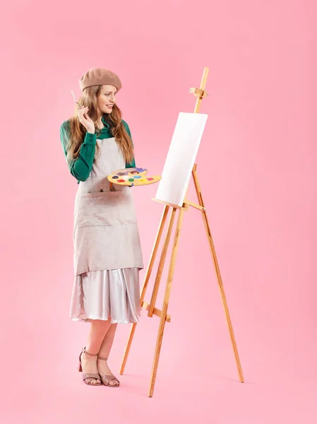 Jonge vrouwelijke kunstenaar op kleur achtergrond — Stockfoto
