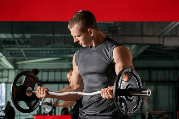 Sporty muscular man training with barbell in gym — Stock Photo, Image