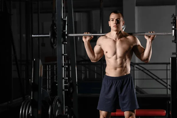 Sporty muscular man training with barbell in gym — 스톡 사진
