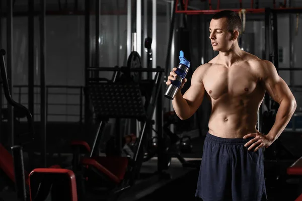 Sporty muscular man drinking water in gym — 스톡 사진