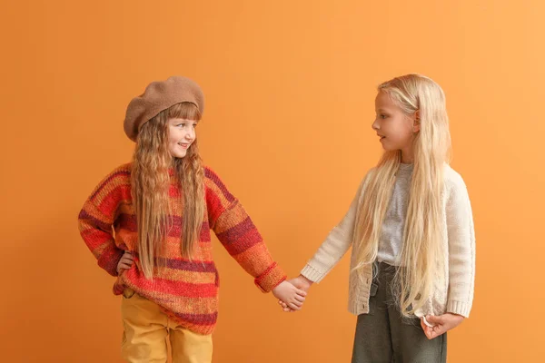 Cute little girls in autumn clothes on color background — Stock Photo, Image