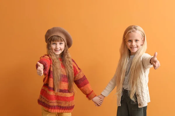 Carino bambine in abiti autunnali che mostrano pollice su sfondo di colore — Foto Stock