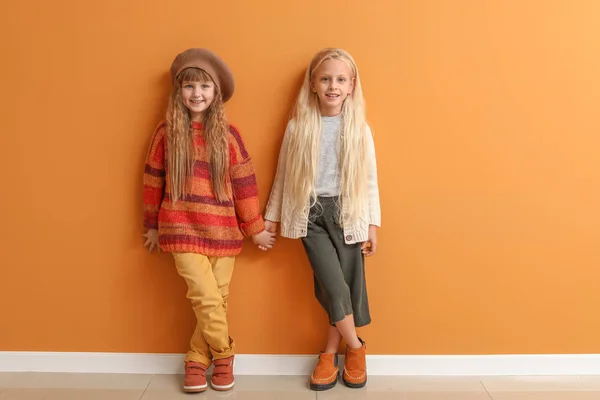 Renk duvarının yanında sonbahar kıyafetleri içinde şirin küçük kızlar. — Stok fotoğraf