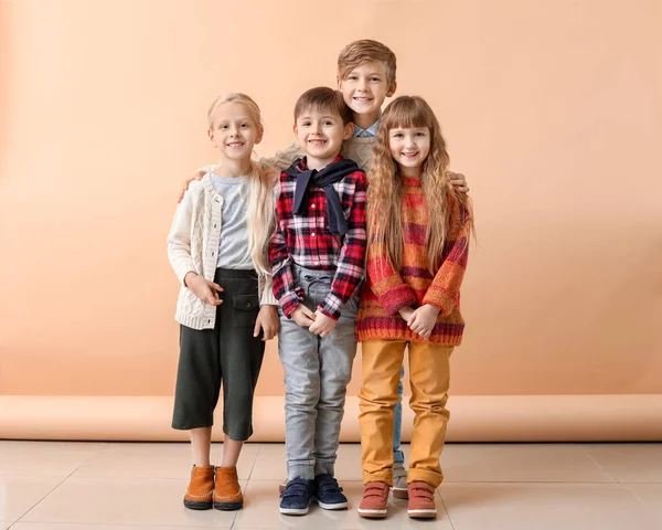 Bambini piccoli e carini in abiti autunnali vicino alla parete di colore — Foto Stock