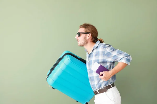 Спешит турист с багажом на цветном фоне — стоковое фото