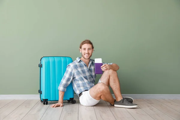 Young tourist with luggage near color wall — Stock Photo, Image