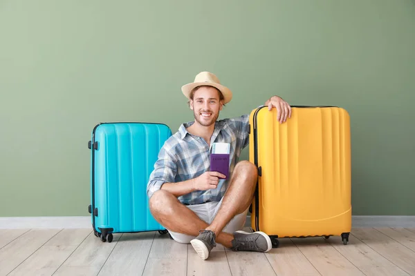 Giovane turista con bagagli vicino parete a colori — Foto Stock