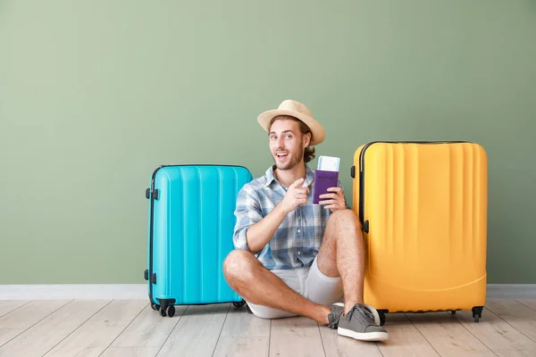 Young tourist with luggage near color wall — 스톡 사진