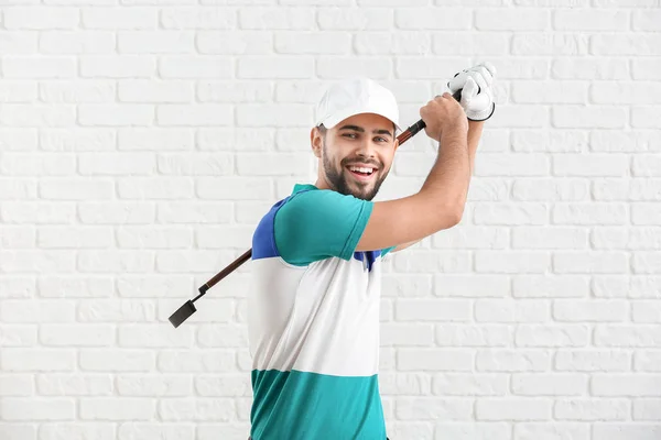 Handsome male golfer on white brick background — 스톡 사진