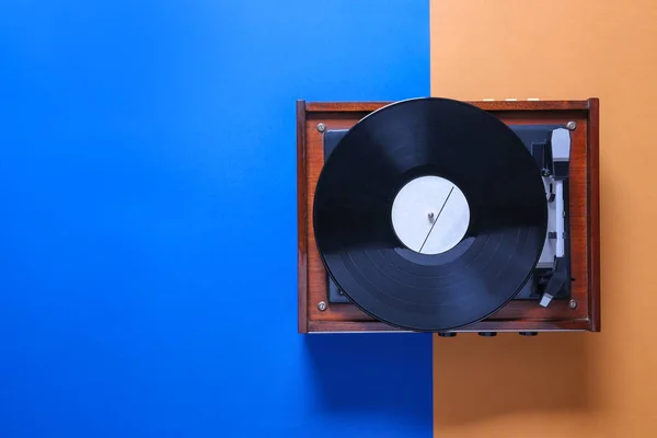 Record player with vinyl disc on color background — Stock Photo, Image