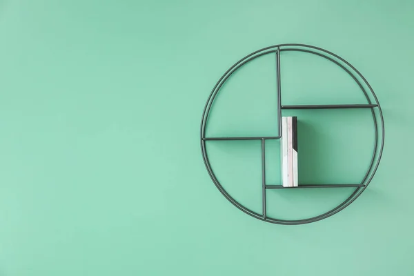 Shelf with notebooks hanging on color wall — 스톡 사진