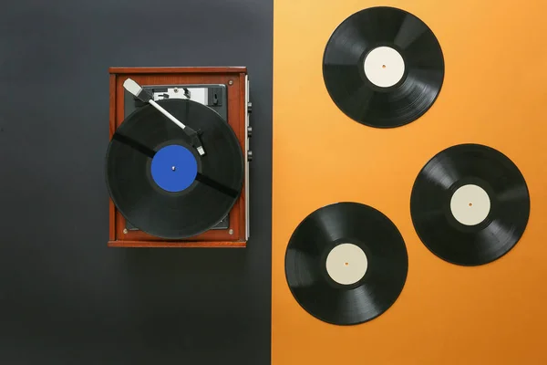 Plattenspieler mit Schallplatten auf farbigem Hintergrund — Stockfoto