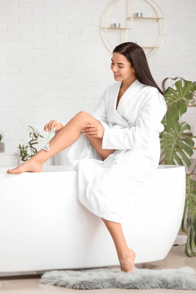 Hermosa mujer joven afeitarse las piernas en el baño — Foto de Stock
