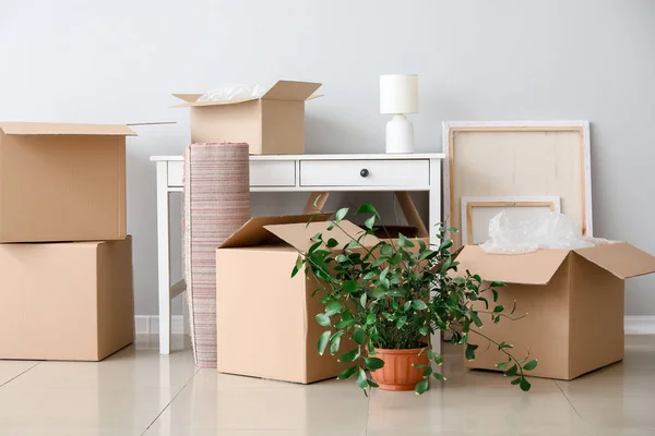 Cajas de cartón con pertenencias y mesa en piso nuevo en día de mudanza — Foto de Stock