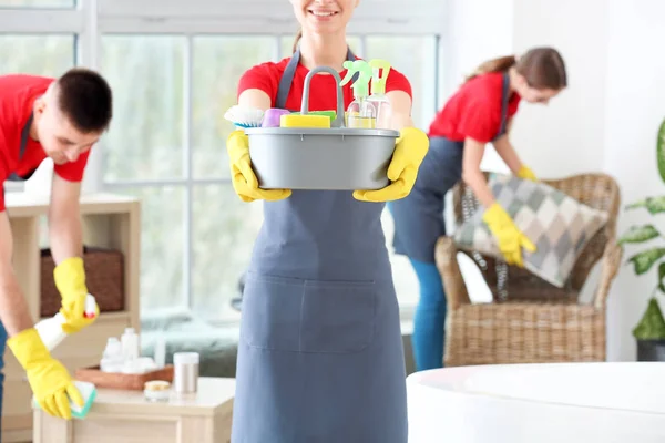 Conciërge met schoonmaakmiddelen in badkamer — Stockfoto