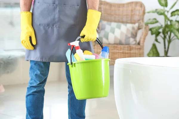 Conciërge met schoonmaakmiddelen in badkamer — Stockfoto