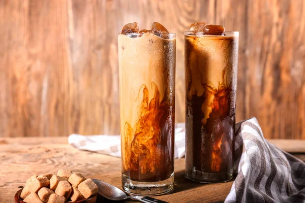 Glasses of tasty cold coffee on wooden table — Stock Photo, Image