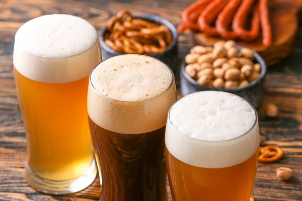 Glasses of different tasty beer on wooden table, closeup — Stock Photo, Image