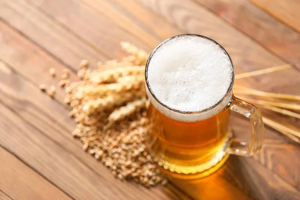 Mug of tasty beer on wooden background — Stock Photo, Image