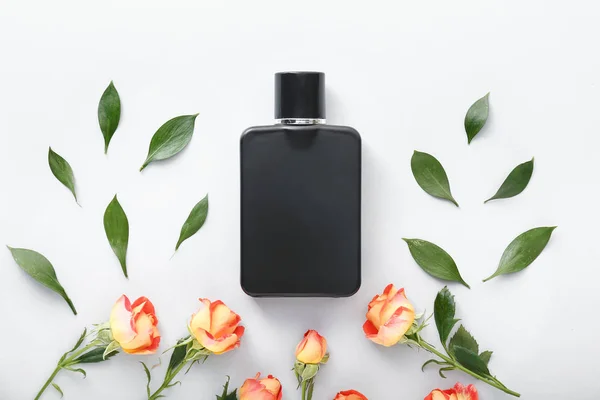 Fles parfum met rozenbloemen op witte achtergrond — Stockfoto