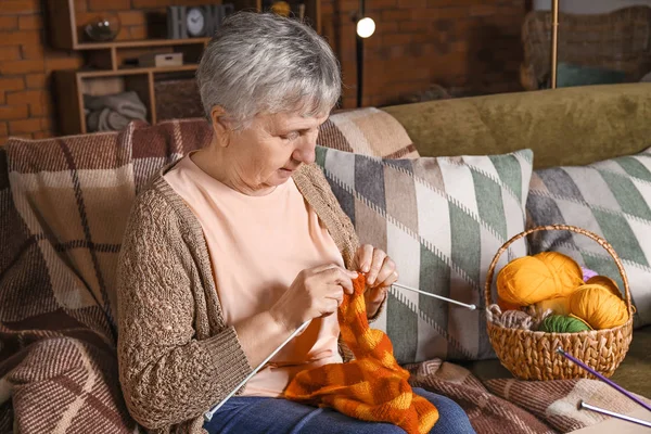 Starší žena pletení doma teplý šátek — Stock fotografie
