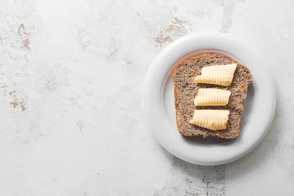 Plate with tasty bread and butter on white background — Stock Photo, Image