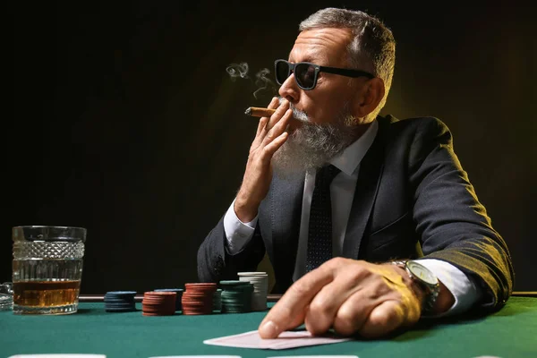 Зрелый бизнесмен играет в казино — стоковое фото