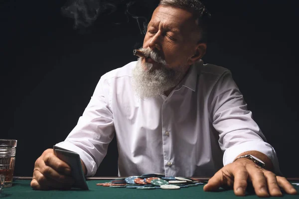 Mature businessman playing in casino — Stock Photo, Image