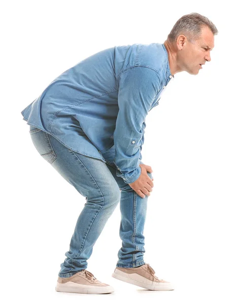 Mature man suffering from pain in knee on white background — Stock Photo, Image