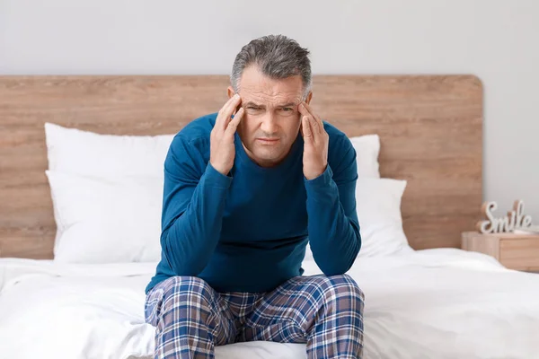 Ώριμος άντρας που υποφέρει από πονοκέφαλο στην κρεβατοκάμαρα. — Φωτογραφία Αρχείου