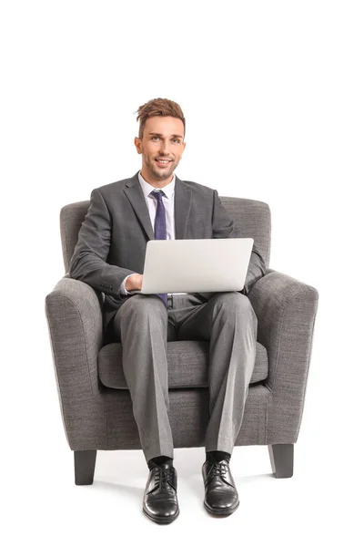 Hombre de negocios guapo con portátil sentado en sillón sobre fondo blanco — Foto de Stock