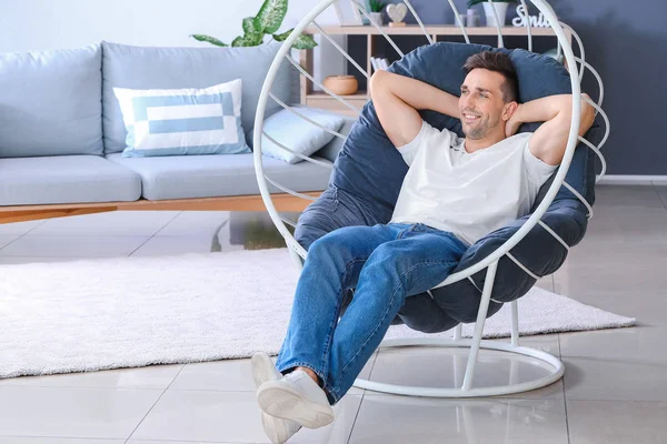 Hombre guapo sentado en sillón en casa — Foto de Stock