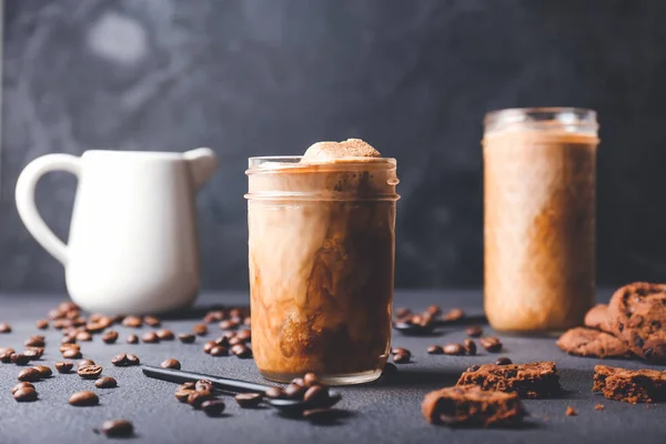 Copo de café gelado saboroso e biscoitos no fundo escuro — Fotografia de Stock