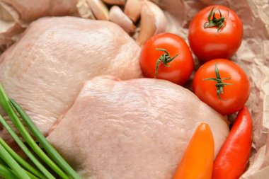 Çiğ tavuk eti ve sebzeler masada, yakın plan.