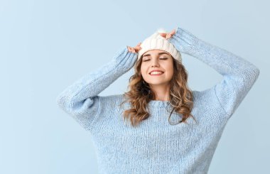 Arka planda kalın süveter giyen güzel bir kadın.