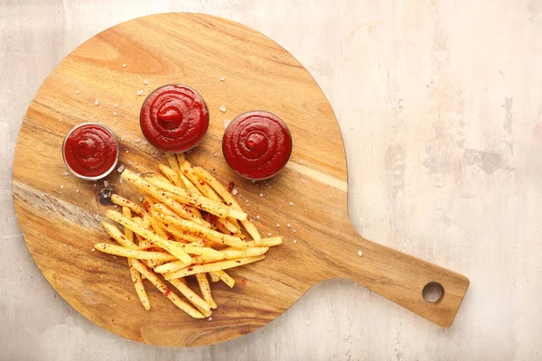 Tasty french fries and tomato sauce on grey background — Stock Photo, Image