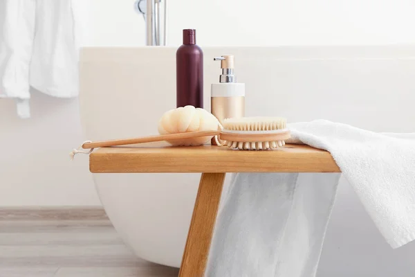 Косметика для догляду за тілом з аксесуарами на лавці у ванній — стокове фото