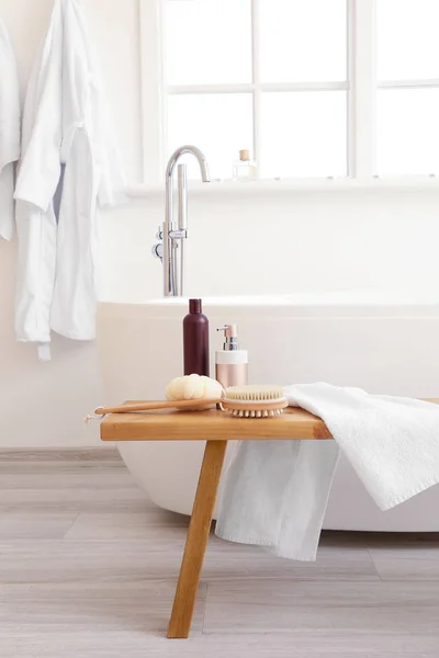 Kosmetik perawatan tubuh dengan aksesoris di bangku di kamar mandi — Stok Foto
