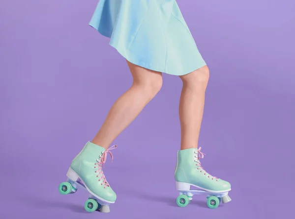 Ноги молодої жінки на ковзанах на кольоровому фоні — стокове фото